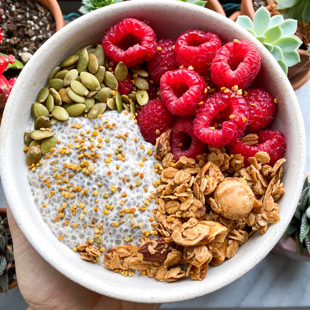 Chia pudding topped with raspberries, granola and pumpkin seeds