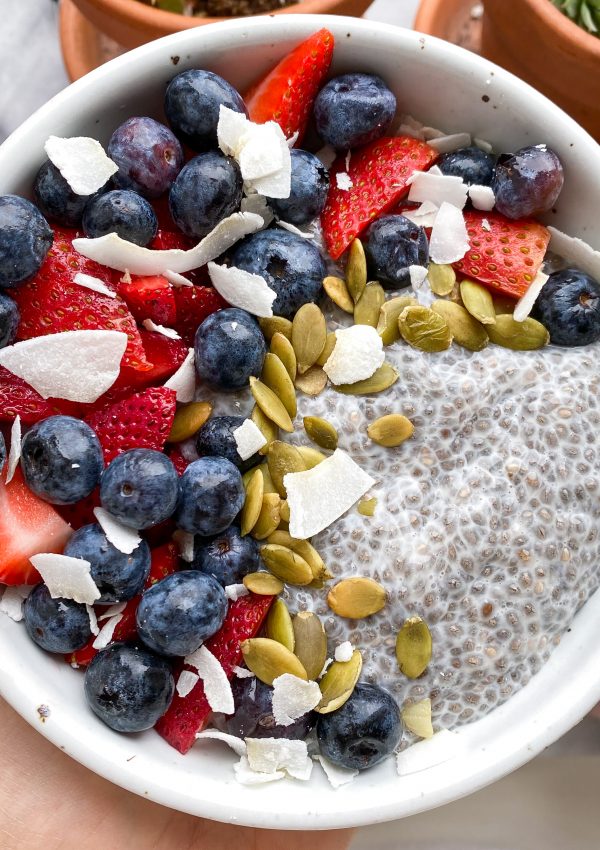Bowl of chia pudding topped with fruit, nuts and granola