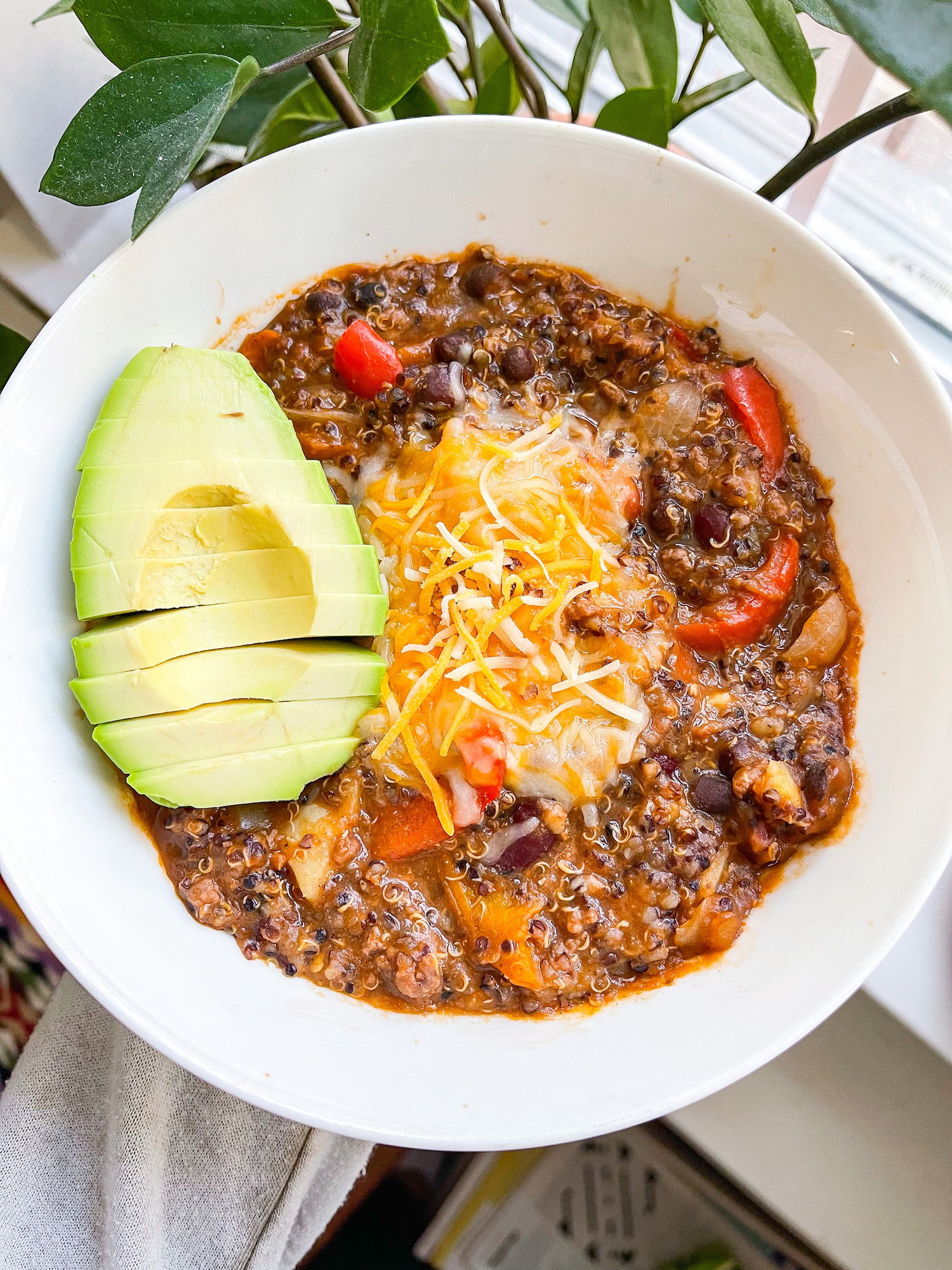 bowl of chili with cheese and avocado